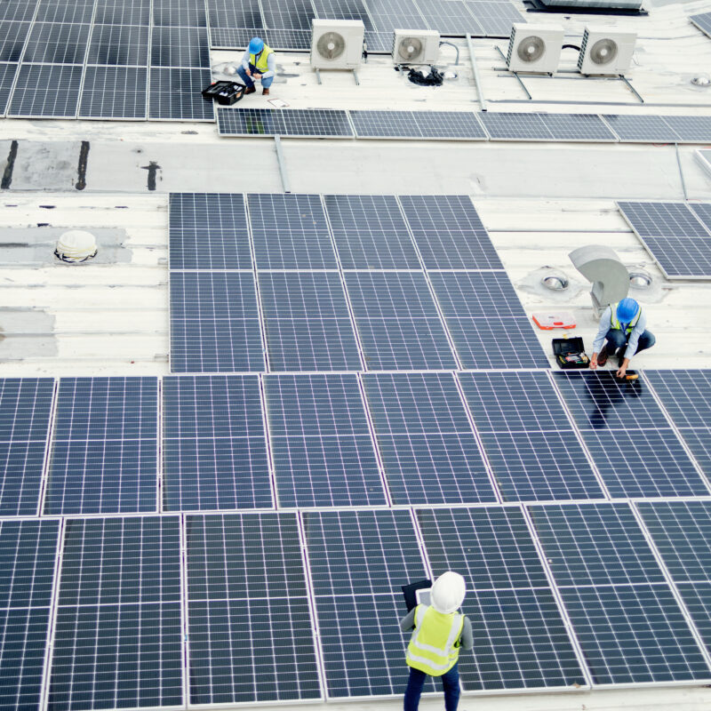 Grid, solar energy and roof construction engineering people working on renewable energy installation. Sustainability, solar panel and professional contractor team work on building rooftop.